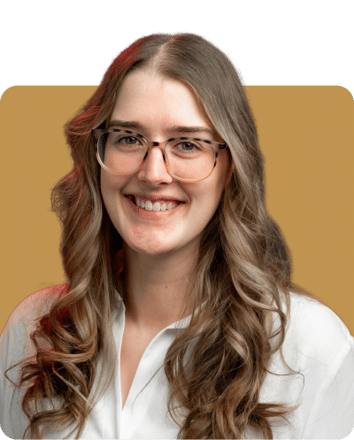 A smiling woman with long, curly hair wearing glasses, dressed in a white shirt, against a golden background.