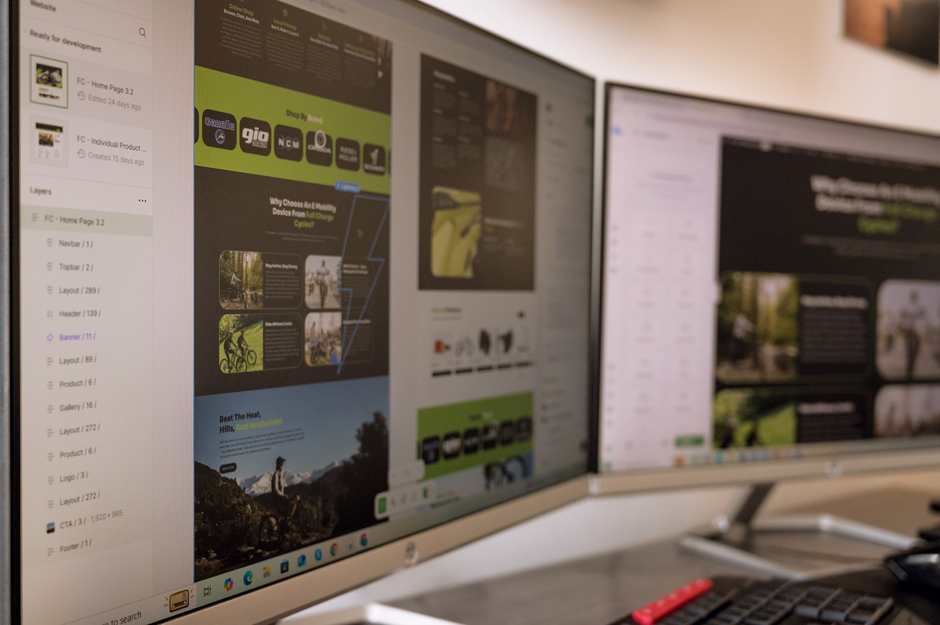 A close-up of computer screens displaying website design and development work, showcasing layouts and elements for a homepage related to cycling products.